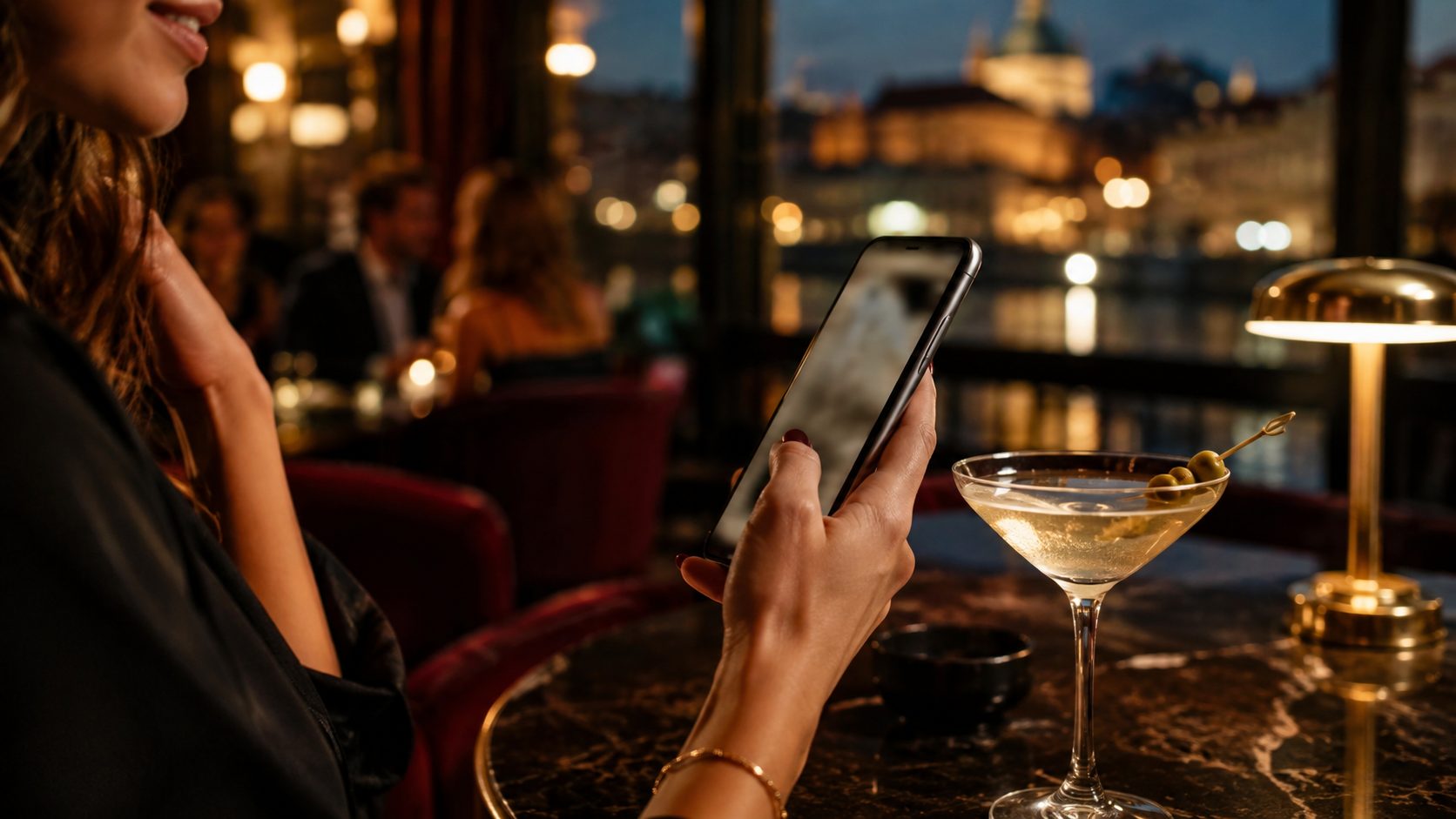 Detail ruky se smartphonem u stolu v baru